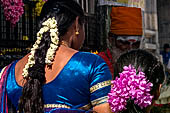 Scented garlands of fresh flowers swaying in women black hair near the Swamimalai temple. 